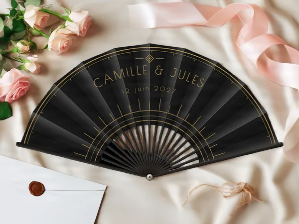 Éventail de mariage personnalisé « Art déco », arcs fins et rayons graphiques Art déco autour du centre, toile : noir, impression : or, posé sur une table de mariage